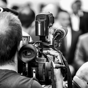 在户外记者招待会上工作的摄影师记者在媒体活动中采访身着正式服装的政治家或商人图片