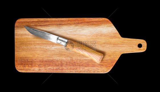 木制切菜板和小刀隔离在黑色背景上木制切菜板和口袋刀隔离在黑色图片