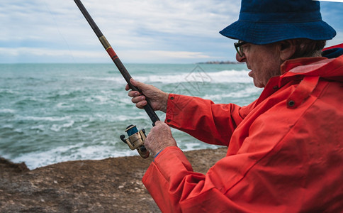 长者在海上钓鱼享受生活钓鱼和运动概念的肖像图片