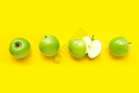 黄色背景上的绿苹果顶视图图片