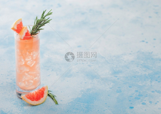 高球杯用冰块水果片和蓝色背景的迷迭香来补充夏季红葡萄园鸡尾酒以及冰块水果片和迷迭香图片