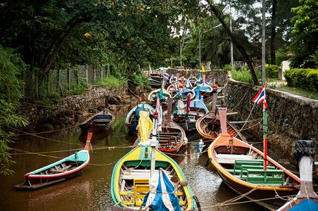 在季风节小运河中用浮壳在季风节用小运河乘许多泰国彩的长尾拖网渔船图片