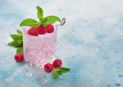 以蓝底草莓冰和薄荷为蓝色背景的粉红柠檬鸡尾酒鲜花冰和薄荷图片