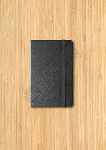 木制背景上隔离的黑色封闭笔记本模型木制背景上的黑色封闭笔记本图片