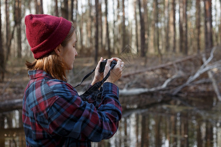 美丽的时髦女孩在森林里拿着摄像头野生环境图片