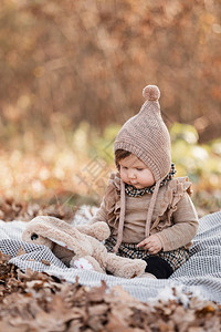 坐在格子上的漂亮女婴户外的孩子阳光明媚的天在秋公园野餐时的孩子漂亮小女孩图片
