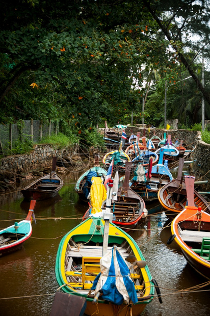 在季风节小运河中用浮壳在季风节用小运河乘许多泰国彩的长尾拖网渔船图片