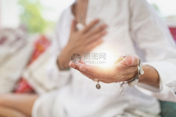 女坐在莲花的姿势上左手掌向抬高以获得积极的能量接受积极的情感手势图片