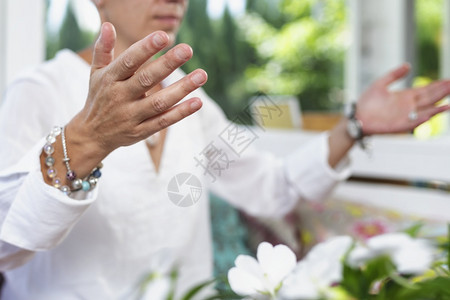 女坐在莲花的姿势上手掌向抬高以获得积极的能量在家里积极的能量冥想练习图片