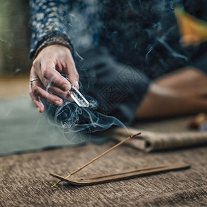 在家里用香棍和手握着石英晶查克拉魔杖的冥想练习用香棍和石英晶查克拉魔杖的冥想练习图片