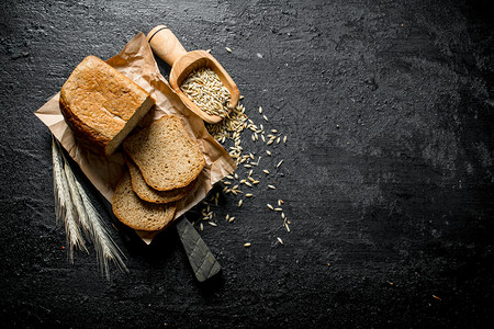 鲜烤面包配有小和谷物黑色生锈背景新鲜面包配有小和谷物图片