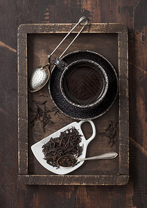 杯形陶瓷板上松散的黑茶用色陶瓷杯木箱装旧式教练器用黑色陶瓷杯装在木箱内图片