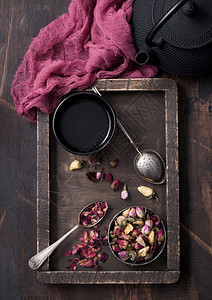 用勺子和训练员的木箱装玫瑰花蕾茶用壶和红布装在木本底的铁杯和茶壶红布图片