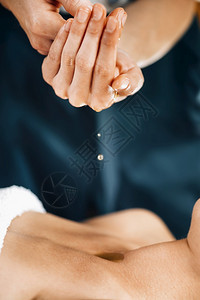Ayurvedic芳香疗法油按摩师持有用于身体按摩的Ayurveda油图片