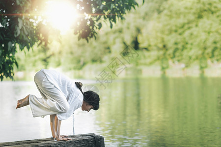在湖边做瑜伽手握平衡或乌鸦摆姿baksn图片