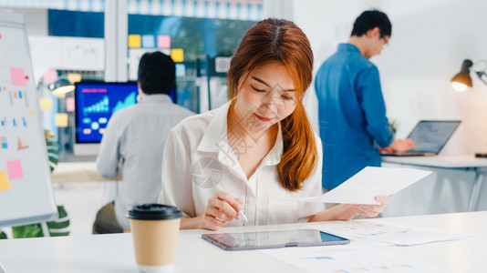 成功的执行者是年轻商业女人她们精巧的散装画写作和使用带数字平板电脑的笔思考现代家庭办公室的灵感搜索想法工作过程图片