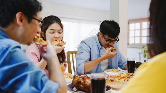 asi家庭聚会吃披萨欢笑饭坐在餐厅桌旁庆祝节假日和聚会图片