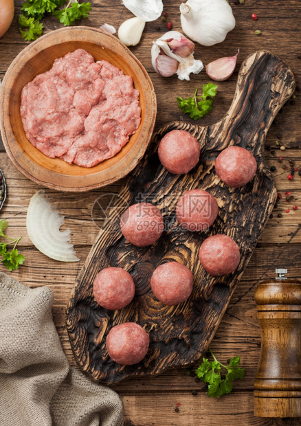 木板上新鲜牛肉生丸碗盘上塞薄饼胡椒盐和大蒜洋葱图片