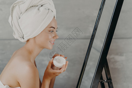 裸露肩膀头上戴浴巾照镜子擦面霜皮肤健康使用天然化妆品图片