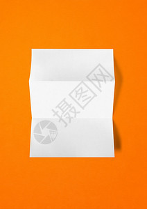 在橙色背景上孤立的白折叠纸页4模拟板白折叠纸页模拟板在橙色背景上图片
