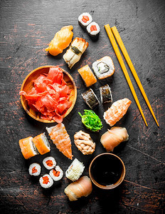 美味的日本寿司和酱油卷深黑的生锈背景图片