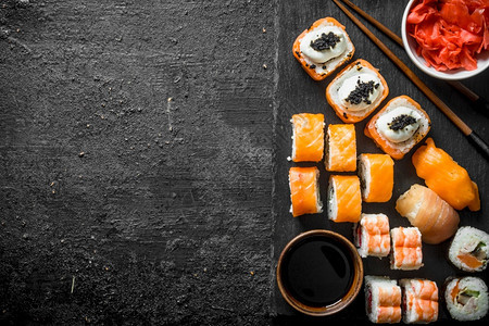 传统的日本寿司卷黑石板上加姜和酱油黑色生锈背景的石板上加姜和酱油传统的日本寿司卷黑石板上加姜和酱油图片