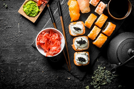 寿司卷有鲑鱼和虾在石架上黑色生锈背景鲑鱼和虾在石架上图片