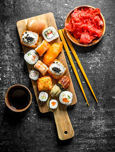 各种类的寿司豆和卷子包括姜汁和酱以及深红的生锈背景各种类的寿司豆和卷子还有姜汁和酱图片