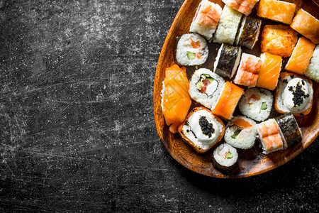 寿司卷三文鱼和蔬菜放在木板上深黑的生锈背景三文鱼和蔬菜放在木板上图片