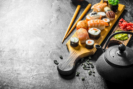 寿司卷配有鲑鱼虾和奶油酪深黑的生锈背景图片