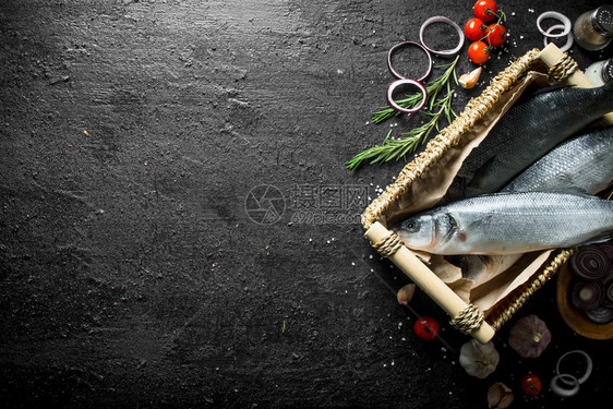 生海盆鱼以黑菜为背景用玫瑰大蒜和樱桃西红柿作为篮子生海盆鱼用玫瑰大蒜和樱桃西红柿作为篮子图片