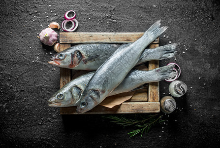 生海贝斯鱼配有香料大蒜和洋葱的盘子上生海贝司鱼配有香料大蒜和洋葱的盘子上图片