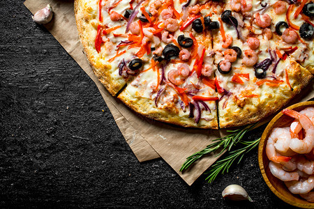 带虾和橄榄的香味海披萨黑生背景带虾和橄榄的香味海披萨图片