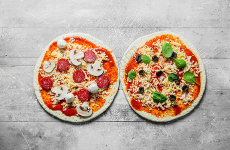 两种不同的生披萨白色木制背景图片