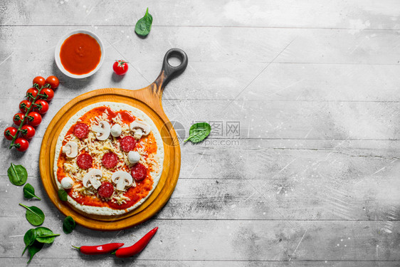 用香肠芝士番茄糊和菠菜铺面白木背景生披萨用香肠奶酪番茄糊和菠菜铺面图片