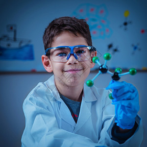 拥有分子模型的可爱男孩在实验室里图片