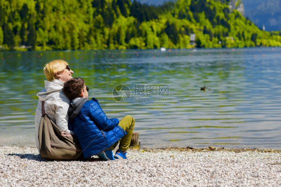 春天母亲和儿子在湖边休息图片