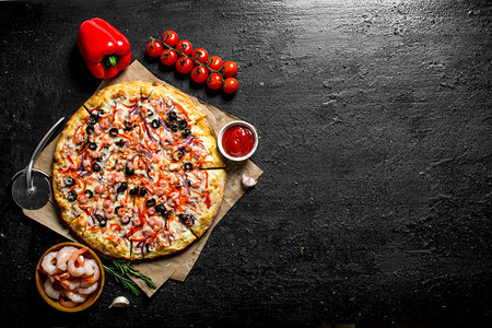 海边披萨配有胡椒西红柿和虾黑生背景配有胡椒西红柿和虾图片