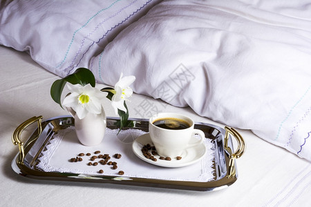 在床上用优雅的银盘喝早起咖啡在精致的刺绣餐巾上喝咖啡这是最好的酒店服务概念图片
