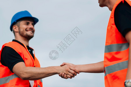 建筑工人在施工现场握手图片
