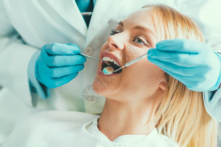 接受牙科检查的年轻妇女图片