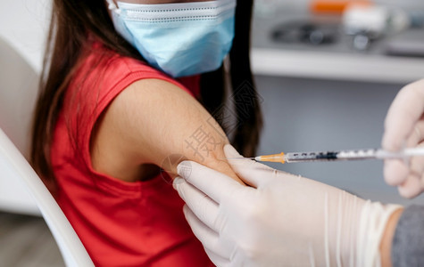 关闭小女孩手臂在医生和rs办公室接受冠状疫苗图片