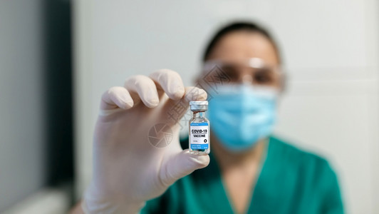 展示科罗纳疫苗小瓶的不可辨认女实验室技术员图片