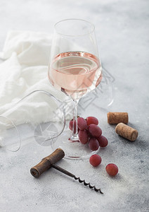 玻璃粉红玫瑰自制葡萄酒有软木箱和葡萄放在光桌背景上图片