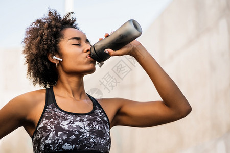 afro运动员女在户外工作后饮用水的肖像运动与健康生活方式afro运动员女在户外工作后饮用水的肖像图片