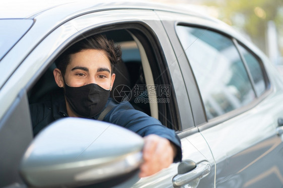 年轻男子驾驶汽车并戴面罩的肖像图片