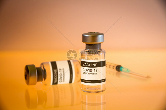 19个疫苗瓶和注射器黄色实验室背景19个疫苗瓶和注射器黄色背景图片