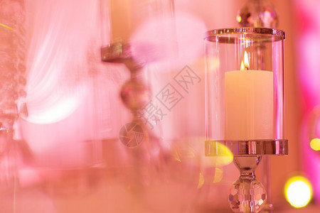 喜庆式婚礼桌用粉红灯光燃烧蜡烛和水晶蜡烛架作为婚礼招待会的中心部分喜庆式婚礼桌作为招待会的中心部分图片