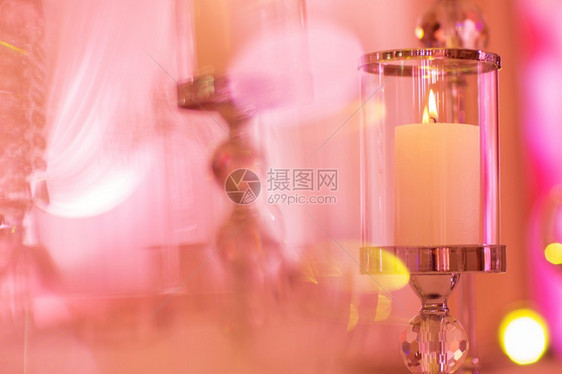 喜庆式婚礼桌用粉红灯光燃烧蜡烛和水晶蜡烛架作为婚礼招待会的中心部分喜庆式婚礼桌作为招待会的中心部分图片
