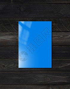 蓝色小册子封面孤立在黑木背景模型模板蓝色小册子封面模板上的黑木背景图片
